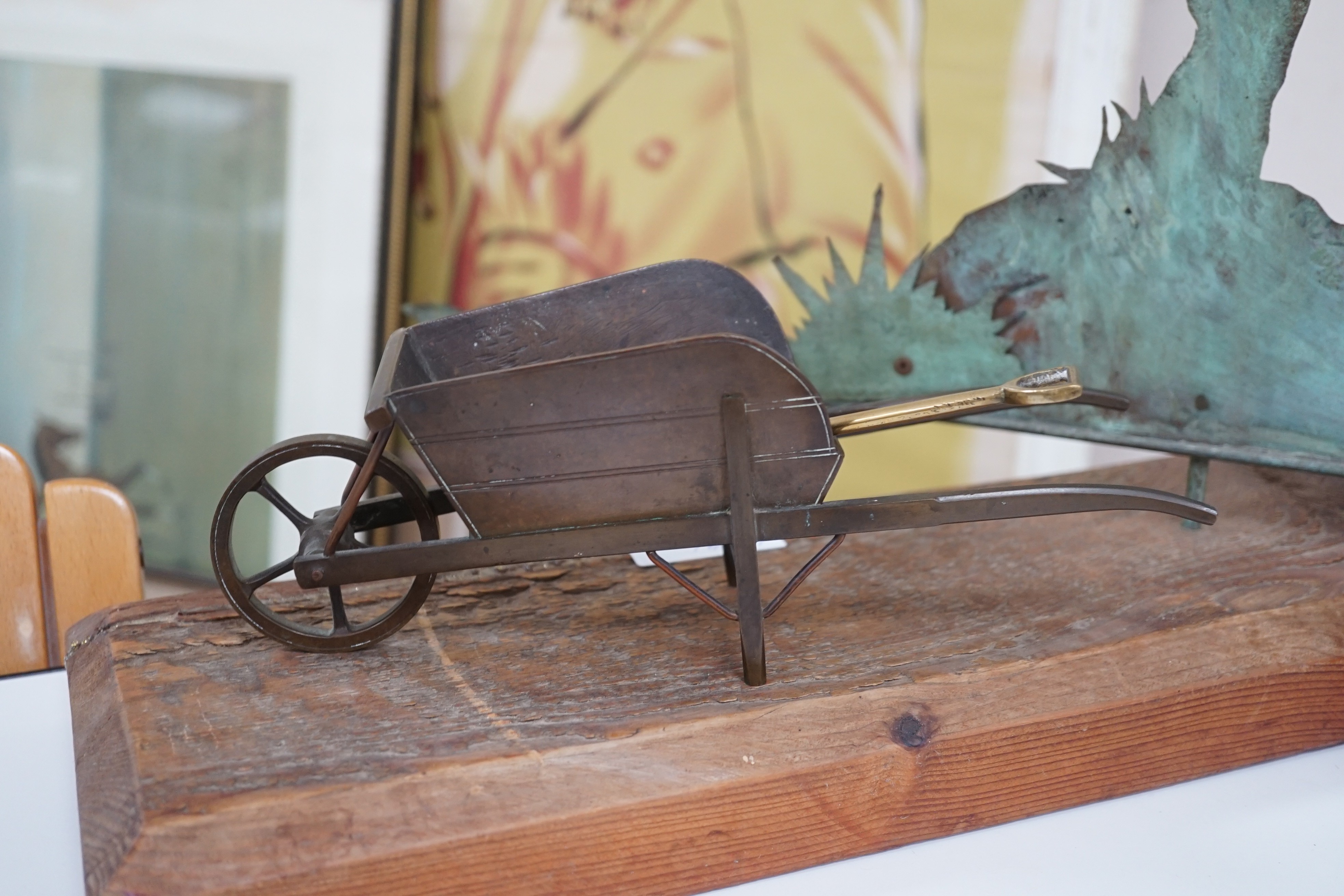 A spelter figural candlestick, a weather vane, a bronze wheel-barrel and a spade, Weather vane 51 cms high not including base